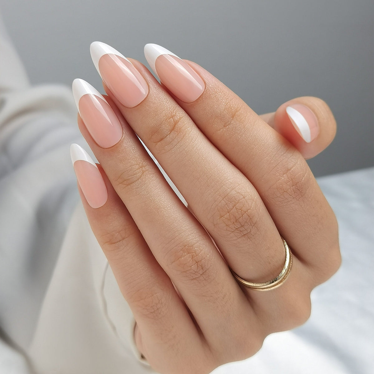 French Nail Nude Press On Nägel in Medium Almond aus einem zweiten Blickwinkel, warmes Nude am Nagelbett mit einer schmal gezogenen weißen Spitze