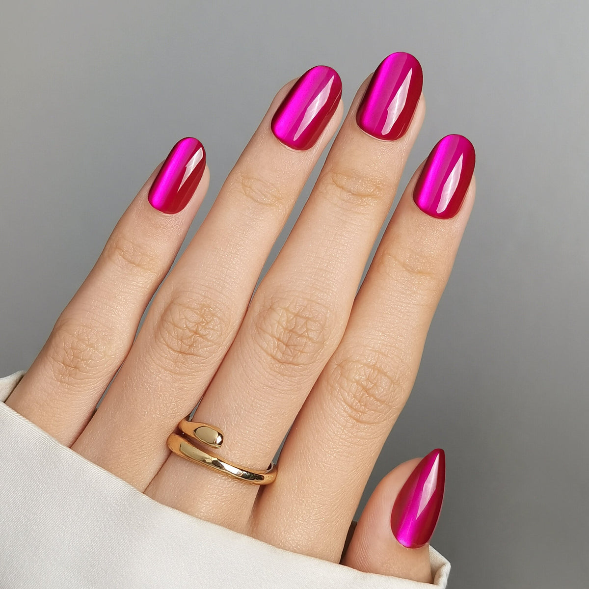 Violet Glitter Press On Nägel in Medium Round aus einem zweiten Blickwinkel, kräftiges Magenta mit metallischem Schimmer und einem hellen Lichtstreifen, der mit dem Blickwinkel wandert