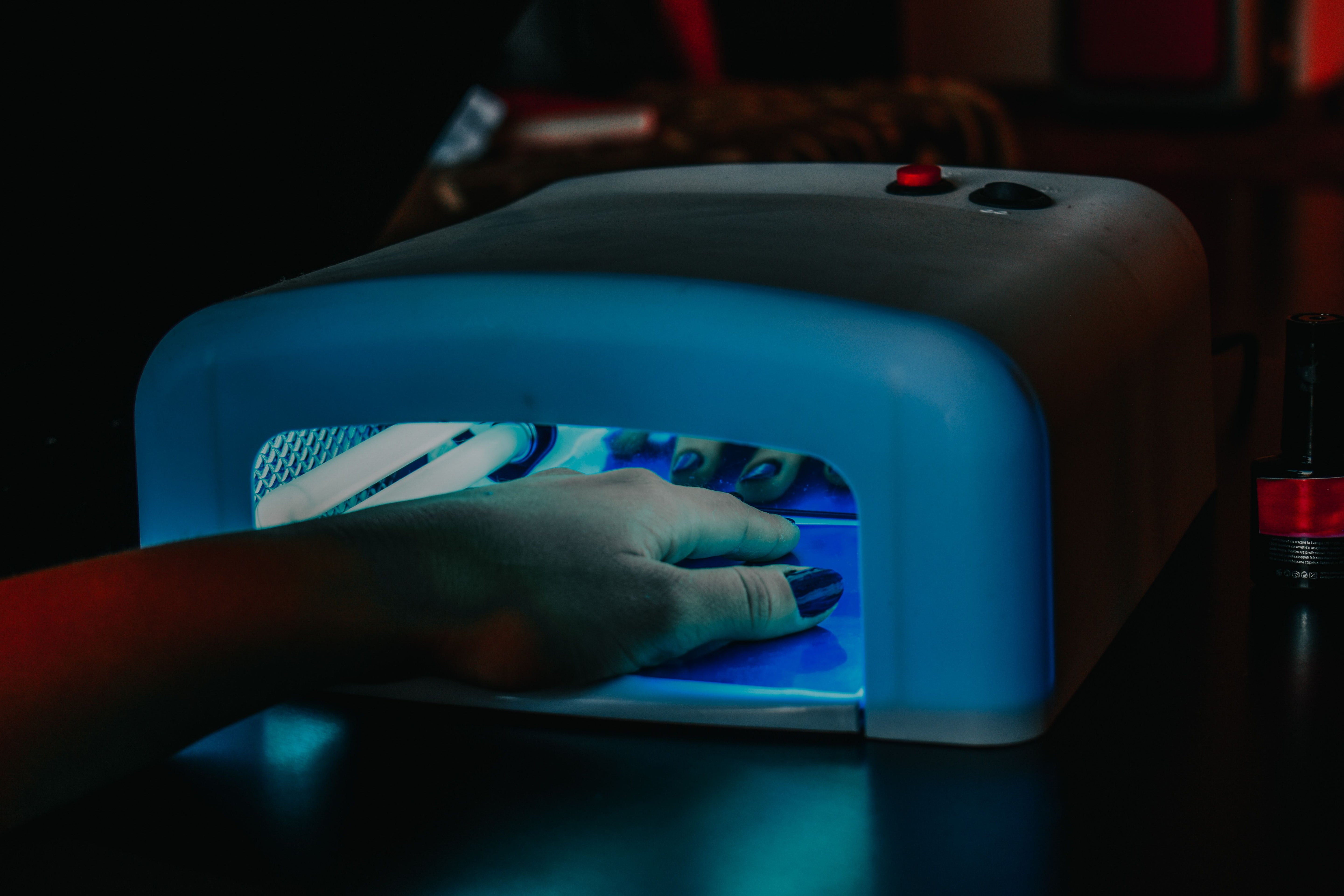 Hand unter UV-Lampe beim Aushärten der NAILUXE UV Gel Strips