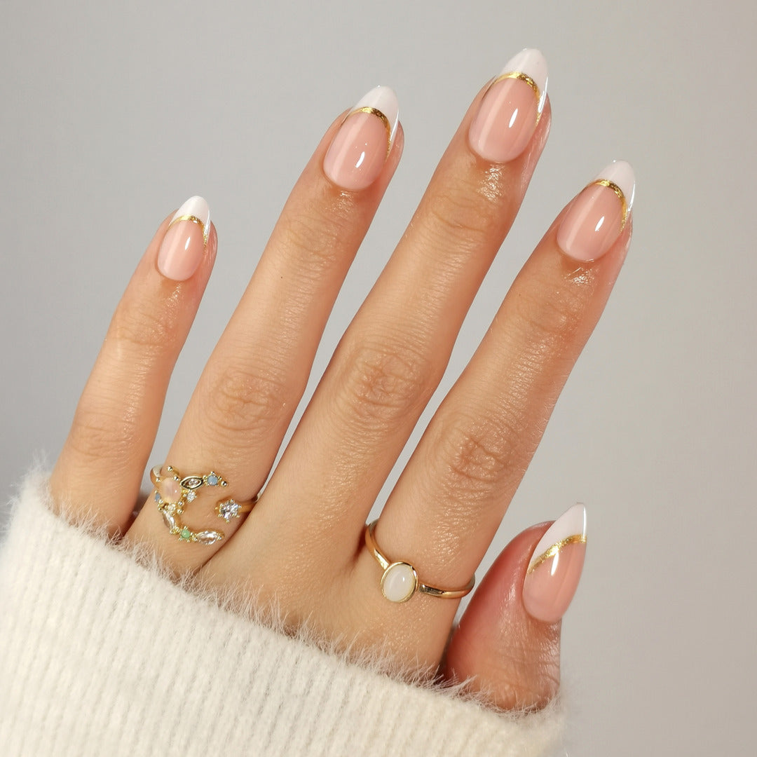 Hand mit French Gold Stripe Press On Nägeln in Short Almond, nude mit Goldlinie