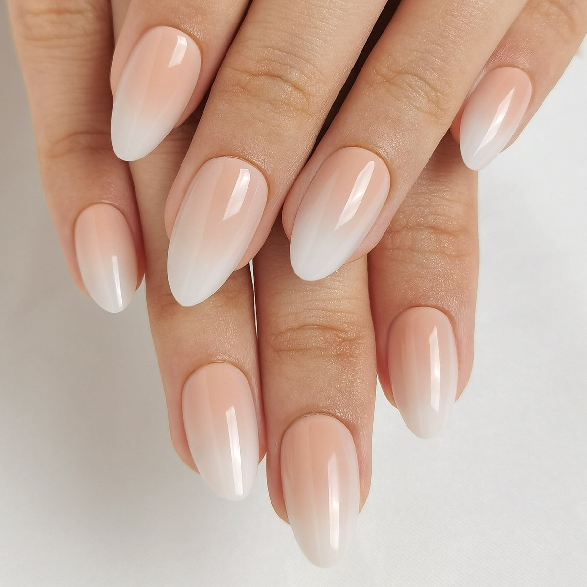 Baby Boomer Light Press On Nägel in Short Almond aus einem zweiten Blickwinkel, heller Nude-Ton am Nagelbett, der weich in ein milchiges Weiß an der Spitze übergeht