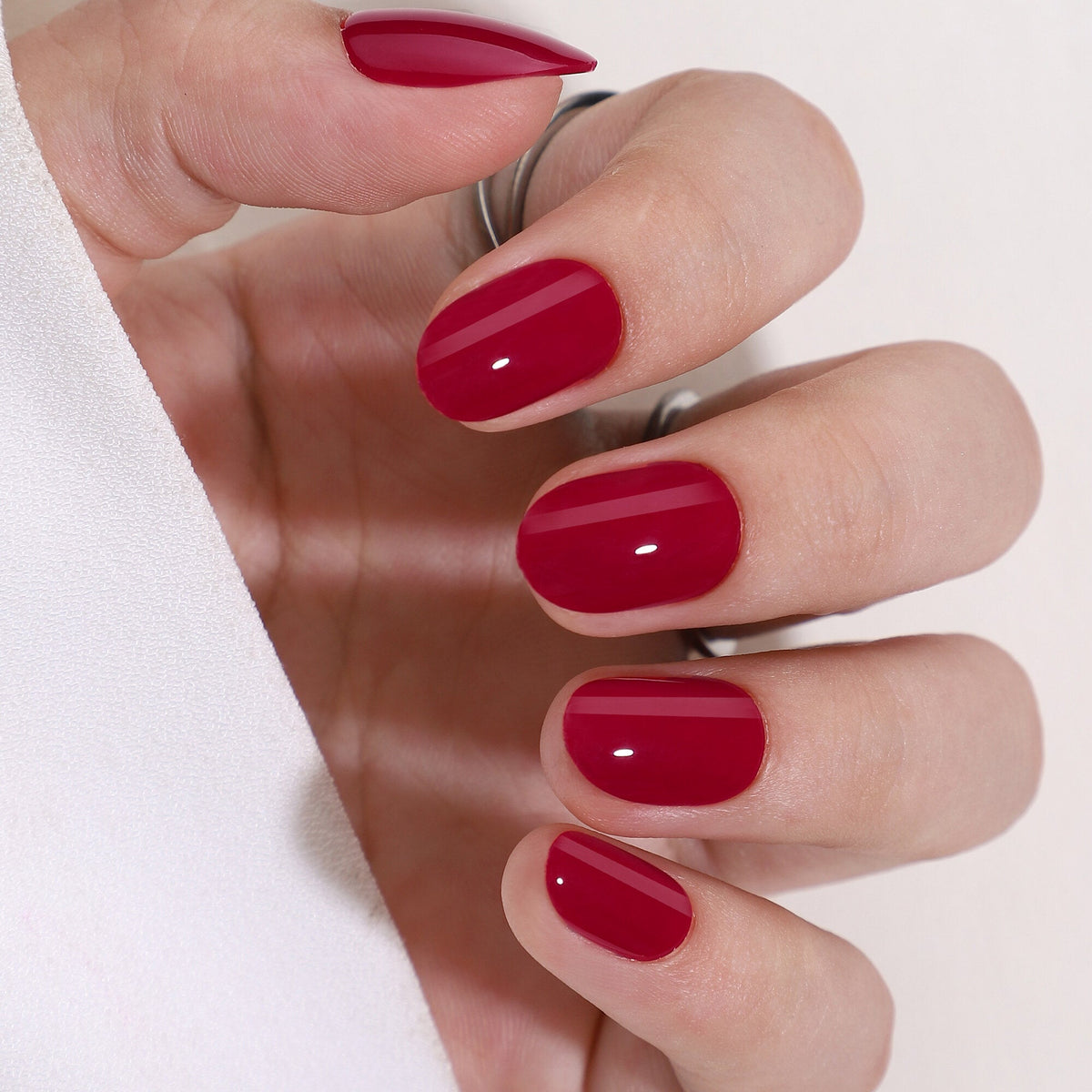 Bonfire Red Press On Nägel in Medium Round aus einem zweiten Blickwinkel, sattes, tiefes Rot mit hoher Deckkraft und glänzendem Finish
