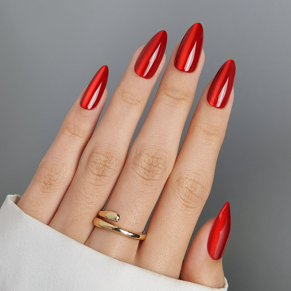 Hand mit Ladies Night Press On Nägeln in Medium Almond, leuchtendes Rot mit metallisch spiegelndem Chrome-Finish