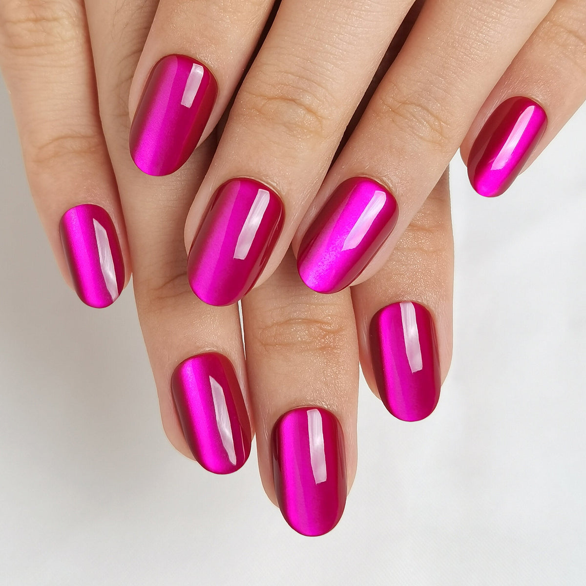 Hand mit Violet Glitter Press On Nägeln in Medium Round, kräftiges Magenta mit metallischem Schimmer und einem hellen Lichtstreifen, der mit dem Blickwinkel wandert